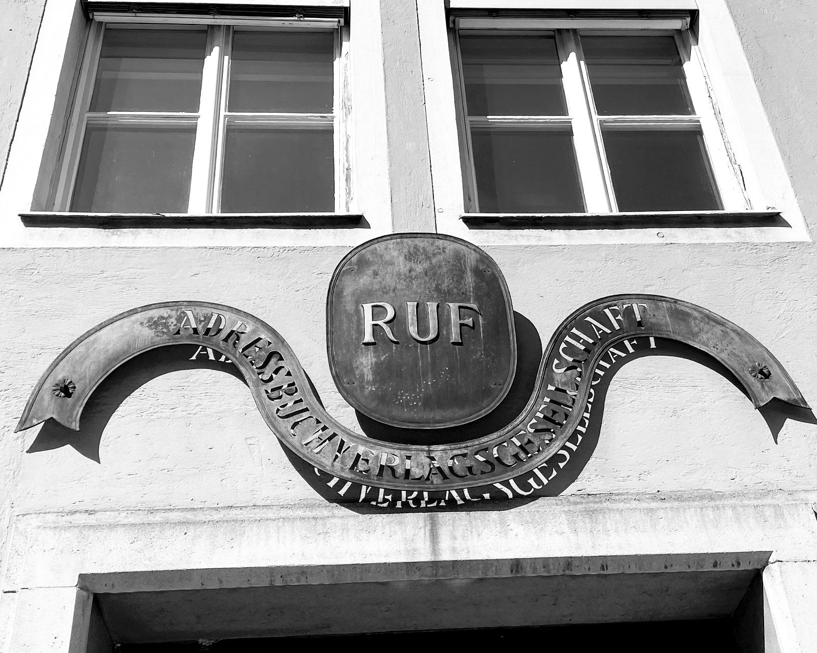 Hauseingan zum Ruf Verlag mit antikem Firmenlogo aus Metall